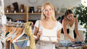 Consumidora joven Gen Z en retail de moda evaluando prendas con estilo casual